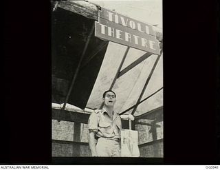 NADZAB, NEW GUINEA. C. 1944-02. LEADING AIRCRAFTMAN E. DUVAL OF BALMAIN, NSW, THE SQUADRON'S "JIVE-BOMBER" SINGING FROM THE STAGE OF THE TIVOLI THEATRE NAMED AFTER THE TIVOLI GIRL PERFORMERS ..