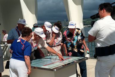 USS ARIZONA survivors and their families view the schematic of the battleship at the USS ARIZONA Memorial following Remembrance Day ceremonies commemorating the 50th anniversary of the Dec. 7, 1941, attack on Pearl Harbor. The schematic shows the configuration of the battleship before and after the bombing