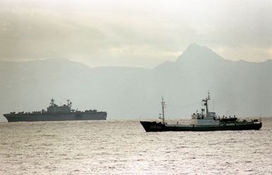 The Soviet Moma class intelligence collection ship ARKHIPELAG observes the amphibious assault ship USS SAIPAN (LHA-2), background, during NATO Exercise Northern Wedding '86