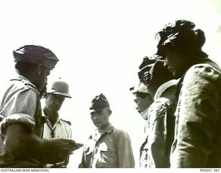 NEW BRITAIN, 1945-09. NEW ZEALAND AND JAPANESE SERVICE PERSONNEL HOLDING A DISCUSSION IN THE RABAUL AREA. (RNZAF OFFICIAL PHOTOGRAPH.)