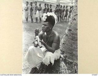 KARKAR ISLAND, NEW GUINEA. 1944-09-19. A DECORATED NATIVE AMONG OTHERS RECRUITED BY MEMBERS OF THE AUSTRALIAN NEW GUINEA ADMINISTRATIVE UNIT TO WORK AT PLANTATIONS ON THE ISLAND