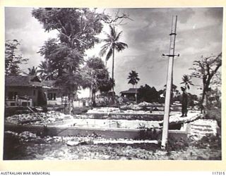 NAURU ISLAND, 1945-09-16. A MEMBER OF THE 31/51ST AUSTRALIAN INFANTRY BATTALION INSPECTING THE RUINS OF ONCE PALATIAL HOMES SOON AFTER THE UNIT HAD TAKEN OVER THE ISLAND FROM THE JAPANESE