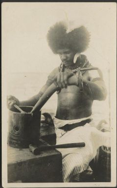 [Native boy, working on a large piston from an engine, the connecting rod is being held and he is tightening/loosening the gudgeon pin with a shifting spanner, Port Moresby, about 1925] Gibson