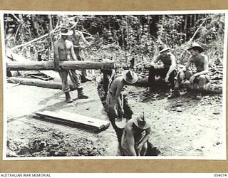 MILNE BAY, NEW GUINEA. 1943-07-12. TROOPS OF THE 18TH PLATOON, "D" COMPANY, 2/1ST AUSTRALIAN PIONEER BATTALION, AIF, BUILDING A DRAIN ACROSS HILL STATION ROAD NEAR TURNBULL'S LOOKOUT. THEY ARE:- ..