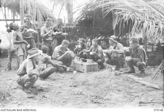 HANSA BAY-BOGIA HARBOUR AREA, NEW GUINEA. 1944-08-01. NO. 3 SECTION, NO. 13 PLATOON, C COMPANY, 30TH INFANTRY BATTALION HAVING A MEAL AT THEIR OUTPOST AT THE MOUTH OF THE SEPIK RIVER. IDENTIFIED ..