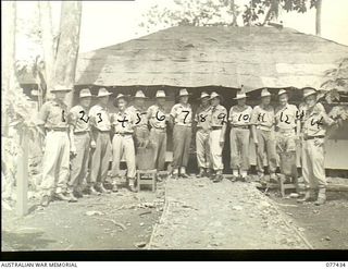 Lae Base Area, New Guinea. 1944-12-01. The Officer-in-Charge and personnel of the 22nd Works Company outside the unit Orderly Room at the conclusion of a unit conference. Left to right: V25941 ..