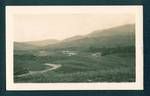 View of road with mountain ranges in background, New Guinea, c1929 to 1932