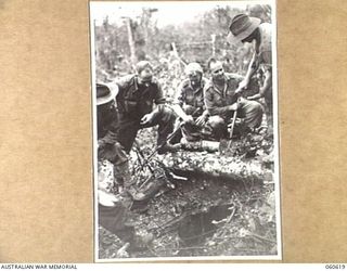 SATTELBERG AREA, NEW GUINEA. 1943-11-18. TROOPS OF C COMPANY, 2/48TH. AUSTRALIAN INFANTRY BATTALION AROUND A JAPANESE DUGOUT SEARCHING FOR DOCUMENTS AND EQUIPMENT. THEY ARE: SX15212 PRIVATE D. J. ..