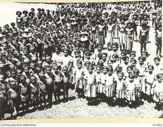 1943-04-05. NEW GUINEA. NATIVE CHILDREN EVACUATED FROM A MISSION AFTER IT HAD BEEN STRAFED BY THE JAPS SING "GOD SAVE THE KING". (NEGATIVE BY N. BROWN)