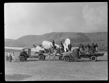 Qantas Empire Airways' personnel and local men, cargo-handling scene, Bulolo Airfield, Morobe, Papua New Guinea