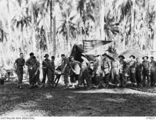 SIAR, NEW GUINEA. 1944-06-19. B3/195 MR A. GREEN, OFFICER- IN- CHARGE, SERVING OUT TEA AND BISBISCUITS TO THE TROOPS OF THE 58/59TH INFANTRY BATTALION AT THE YOUNG MEN'S CHRISTIAN ASSOCIATION TENT. ..