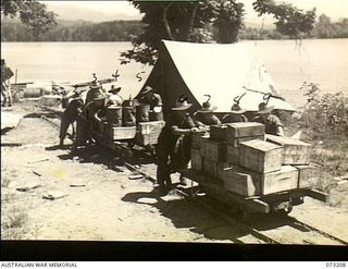 ALEXISHAFEN, NEW GUINEA. 1944-05-15. MEMBERS OF THE 2/15TH FIELD AMBULANCE MAKING USE OF THE OLD TROLLEYS AND LINES AT THE CATHOLIC MISSION TO TRANSPORT STORES FROM THE WHARF TO THE UNIT. THE LINES ..