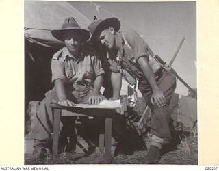 AWAR POINT, NEW GUINEA. 1944-07-09. LIEUTENANT E. BEATTIE, OFFICER- IN- CHARGE, NO.14 PLATOON, C COMPANY, 30TH INFANTRY BATTALION (1) WITH SERGEANT N. HARTLEY, (2), DISCUSSING PLANS FOR A PATROL OF ..