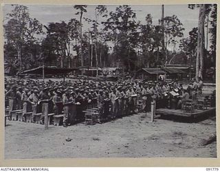 BOUGAINVILLE. 1945-05. TROOPS OF HEADQUARTERS 2 CORPS ATTENDING SPECIAL PRAYERS AND OUTDOORS CHURCH SERVICE CONDUCTED BY CHAPLAIN F.O. HULME-MOIR ON THE CESSATION OF HOSTILITIES IN EUROPE