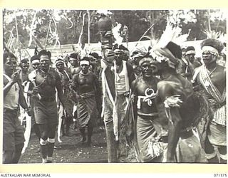 SONG RIVER, FINSCHHAFEN AREA, NEW GUINEA. 1944-03-26. MARKHAM RIVER BOYS DANCING AROUND A TOTEM POLE DURING A NATIVE SING-SING IN THE AUSTRALIAN NEW GUINEA ADMINISTRATIVE UNIT COMPOUND TO CELEBRATE ..