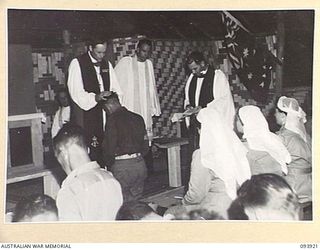 TOROKINA, BOUGAINVILLE, 1945-07-12. CHAPLAIN GENERAL C.L. RILEY, CHURCH OF ENGLAND (1), OFFICIATING AT CONFIRMATION SERVICE IN THE NEW CHAPEL AT HEADQUARTERS 2 CORPS. FIFTY-THREE MEMBERS WERE ..