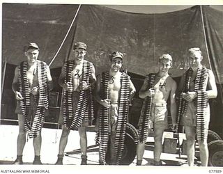 ARMOURERS OF NO. 30 SERVICING UNIT, ROYAL NEW ZEALAND AIR FORCE WITH BELTS OF 5" AIRCRAFT AMMUNITION WHICH THEY HAVE JUST BELTED. IDENTIFIED PERSONNEL ARE:- LEADING AIRCRAFTMAN S.H. BURNS (1); ..