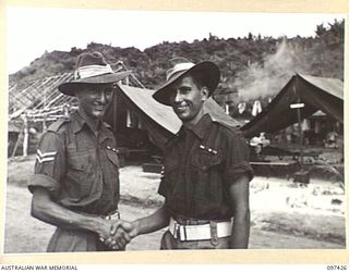 WEWAK POINT, NEW GUINEA. 1945-10-02. CORPORAL G.A. LAMBERT (1) AND SERGEANT E. HAYLETT (2) MEMBERS OF 12 PLATOON, WHO HAVE BEEN JUST PRESENTED WITH MILITARY MEDAL RIBBONS AT A FORMAL PARADE OF C ..