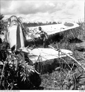 PAPUA. 8 JANUARY 1943. CAPTURED AIR-STRIP AT BUNA. JAPANESE LEFT BEHIND PLANES STRAFED BY ALLIED FIGHTERS. NOTE BULLET HOLES IN WING OF ZERO AIRCRAFT. THIS IS ONE OF THE NEW TYPE SQUARE WING ZERO