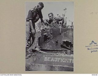 BOUGAINVILLE, 1945-05-16. PERSONNEL OF B SQUADRON, 2/4 ARMOURED REGIMENT INSPECTING A DIRECT HIT ON A MATILDA TANK RECEIVED FROM JAPANESE ARTILLERY. IDENTIFIED PERSONNEL ARE:- CAPTAIN D.B. HILL ..