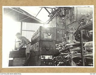 17 MILE, PORT MORESBY AREA, NEW GUINEA. 1943-12-13. STACKS OF DAMAGED VICKERS GUN TRIPODS AND .5 ANTI-TANK RIFLES AT THE ARMOURY WORKSHOPS, RETURNED STORES DEPOT, 10TH AUSTRALIAN ADVANCED ORDNANCE ..