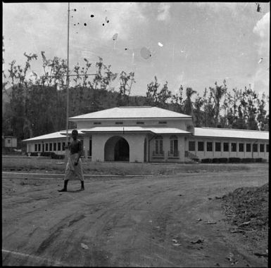 Man walking past a large European style building, Rabaul, New Guinea, 1937 / Sarah Chinnery