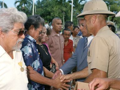 Governor Ricardo J. Bordallo of Guam shakes hands with one of the 34 recipients of the Asiatic-Pacific Campaign Medal and the World War II Victory Medal during a Veterans Day memorial service held at Skinner Plaza