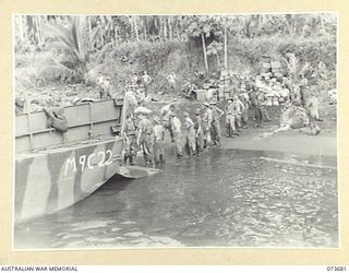 SARANG HARBOUR, NEW GUINEA. 1944-05-31. TROOPS AND STORES OF THE 37/52ND INFANTRY BATTALION UNLOADING FROM AN AMERICAN LANDING BARGE. THE AREA WAS USED AS A FORWARD BASE DURING PREPARATIONS FOR THE ..