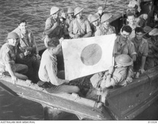 1942-10-01. NEW GUINEA. MILNE BAY. AUSTRALIAN TROOPS RIDE IN A CAPTURED LANDING BARGE USED IN THE UNSUCCESSFUL JAPANESE ATTACK ON MILNE BAY