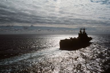 A silhouetted starboard quarter view of the amphibious assault ship USS SAIPAN (LHA 2) underway during NATO Exercise NORTHERN WEDDING 86