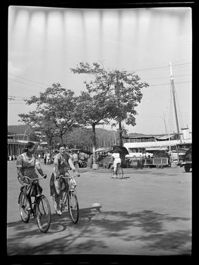 Street scene with two women riding their bicycles, Papeete, Tahiti