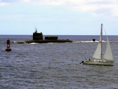 A port side view of the USS KAMEHAMEHA (SSN 642) underway as it enters the Apra Harbor, Guam. A small commercial sailboat is pictured in the foreground