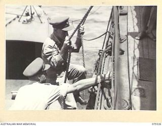 AITAPE, NEW GUINEA. 1945-02-28. VX17 MAJOR-GENERAL J.E.S. STEVENS, DSO, ED, GENERAL OFFICER COMMANDING 6TH DIVISION, CLIMBING ABOARD THE RAN VESSEL HMAS "SWAN". IN THE LAUNCH IS NX24346 LIEUTENANT ..