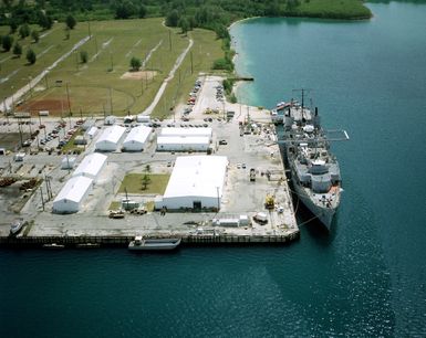 An aerial view of the submarine tender USS PROTEUS (AS 19) moored in the harbor