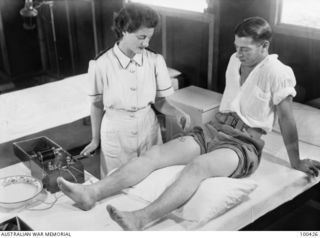 Port Moresby, New Guinea. 1944-05-09. VFX138546 Lieutenant M. Chalmers, of the Physiotherapy Department, 128th Australian General Hospital, using the Bristow electric coil to stimulate the weak leg ..