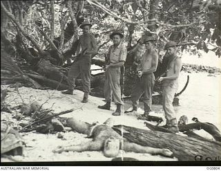 LOS NEGROS ISLAND, ADMIRALTY ISLANDS. 1944-03-18. RAAF GUARDS ON PATROL FOR SNIPERS NEAR THE CAMP AREA AT MOMOTE FIND THE BODY OF A DEAD JAPANESE MARINE ON THE BEACH