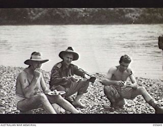 NEW GUINEA. 1943-07-28. SENIOR SIGNALS OFFICERS EATING LUNCH ON THE BANKS OF THE WARIA RIVER. LEFT TO RIGHT:- VX89051 LIEUTENANT COLONEL J. P. DOWNEY MM, COMMANDING OFFICER NO. 18 LINES OF ..