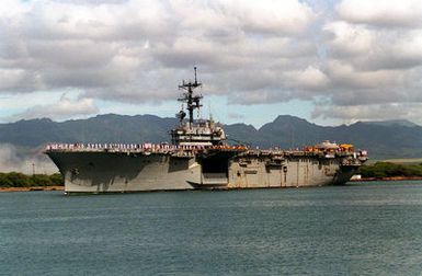 Sailors man the rails aboard the amphibious assault ship USS TRIPOLI (LPH-10) as it departs from the naval station after a visit. The TRIPOLI is en route to its home port of Naval Station, San Diego, Calif., after serving in the Persian Gulf region during Operation Desert Shield and Operation Desert Storm.