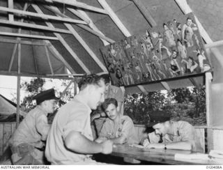 NEW GUINEA. C. 1943-11-12. PLAYING CARDS AND WRITING ARE FLIGHT SERGEANT R. L. WEIDENBACH, MT PLEASANT, SA; FLYING OFFICER (FO) W. S. NEEDHAM, ADELAIDE, SA; PILOT OFFICER R. L. HURLEY, CRONULLA, ..