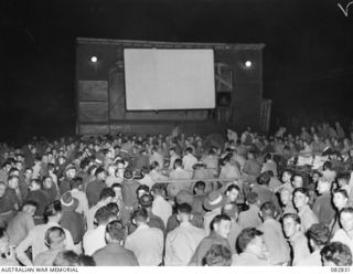 LAE AREA, NEW GUINEA. 1944-11-12. TROOPS EAGERLY AWAITING THE SCREENING OF THE MELBOURNE CUP ARRANGED BY AUSTRALIAN ARMY AMENITIES SERVICE ATTACHED FIRST ARMY HQ