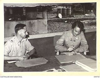 LAE AREA, NEW GUINEA, 1945-08-08. MAJOR R.R. BALFE, CHIEF AUDITOR NEW GUINEA (1), AND CORPORAL L. LOBB (2), MEMBERS OF ARMY AUDIT STAFF, FIRST AUSTRALIAN ARMY