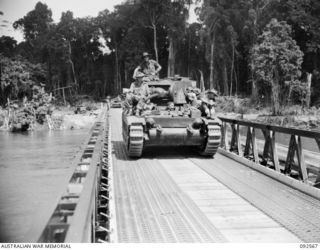 BOUGAINVILLE. 1945-05-23. A MATILDA TANK OF A SQUADRON, 2/4 ARMOURED REGIMENT, CROSSING THE NEW MCKINNA BRIDGE OVER THE PURIATA RIVER DURING THE SQUADRON'S MOVE DOWN THE BUIN ROAD TO RELIEVE B ..