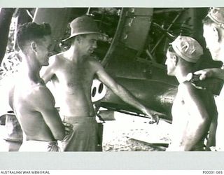 THE SOLOMON ISLANDS, 1945-02-26. AUSTRALIAN AND NEW ZEALAND AIRMEN DISCUSS AIRCRAFT OVERHAUL PROCEDURES. (RNZAF OFFICIAL PHOTOGRAPH.)