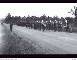 LAE, NEW GUINEA, 1946-02-14. AT A SPECIAL PARADE, MAJOR GENERAL B.M. MORRIS,GENERAL OFFICER COMMANDING AUSTRALIAN NEW GUINEA ADMINISTRATIVE UNIT, PRESENTED GIFTS (FRAMED COLOURED PHOTOGRAPHS OF ..