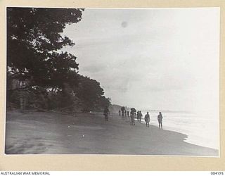 SUAIN PLANTATION, NEW GUINEA. 1944-12-09. NATIVE CARRIERS MOVING ALONG IN THE MAIN LINE OF COMMUNICATION BETWEEN BABIANG AND SUAIN PLANTATION. AT LOW TIDE JEEPS ALSO MAKE FAST TRIPS CARRYING URGENT ..