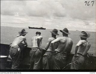 AT SEA IN THE ADMIRALTY ISLANDS AREA. 1944-03-08. BARE-CHESTED RAAF AIRMEN LINING THE RAIL OF THEIR SHIP TO WATCH OTHER VESSELS IN THE CONVOY WHICH TOOK REINFORCEMENTS TO THE ADMIRALTY ISLANDS