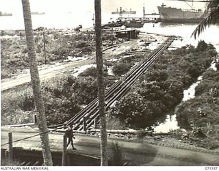 MILNE BAY, PAPUA, NEW GUINEA. 1944-04-03. PIPELINES LEADING FROM THE OIL TANKER 'EMPIRE SILVER', BERTHED IN THE BACKGROUND TO BULK OIL INSTALLATIONS AT THE 2ND BULK PETROLEUM STORAGE COMPANY. THE ..