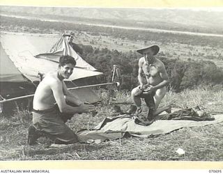 RAMU VALLEY, NEW GUINEA, 1944-02-29. NX162152 PRIVATE W.O. WILLIAMS ( ), WITH QX20553 PRIVATE H.C. MILLS ( ), MEMBERS OF MORTAR PLATOON, 2/12TH INFANTRY BATTALION, RUBBING THEIR CLOTHES WITH ..