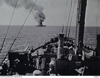PACIFIC OCEAN. 1940-06-12. MEMBERS OF THE SHIP'S COMPANY OF THE ARMED MERCHANT CRUISER HMAS MANOORA GATHERED AROUND THE PORT 6 INCH GUN ON HER FORECASTLE TO WATCH THE SINKING OF THE ITALIAN LINER ..