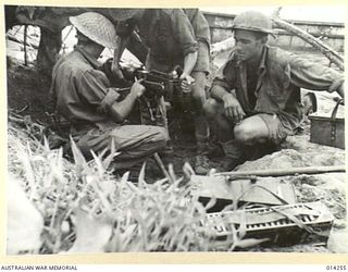 1943-01-27. PAPUA. SANANANDA AREA. AUSTRALIAN MACHINE GUNNERS ON SANANANDA BEACH OVERHAUL THEIR VICKERS MACHINE GUN AFTER HAVING BEEN IN ACTION. (NEGATIVE BY BOTTOMLEY)